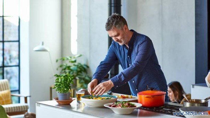 Man in his 50s dressing salad at home, making lunch, enjoyment, healthy lifestyles